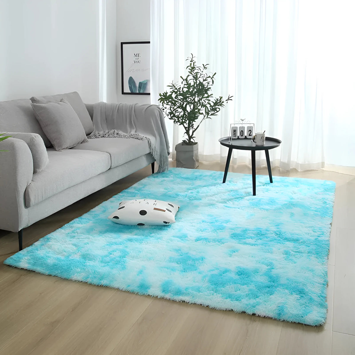 Soft fluffy plain rectangle carpet with anti-slip dots on backing, shown in a light grey colour on a wooden floor.