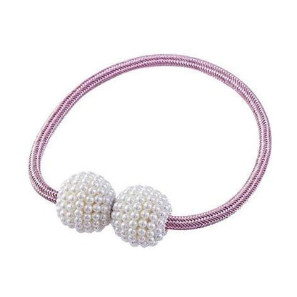 Magnetic curtain tiebacks with white pearl beads and fabric loops holding gathered curtain