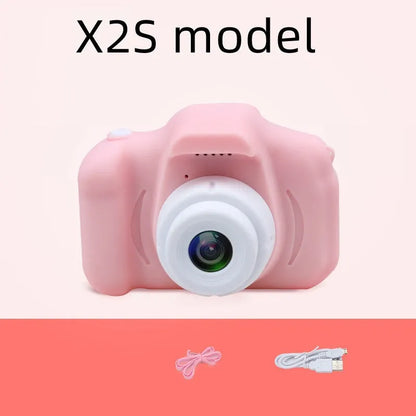 X2 HD mini digital camera for kids in silicone case with lanyard, shown capturing photo on 2-inch screen.