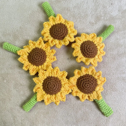 Hand-woven yellow and brown sunflower pen cover holding a pen.