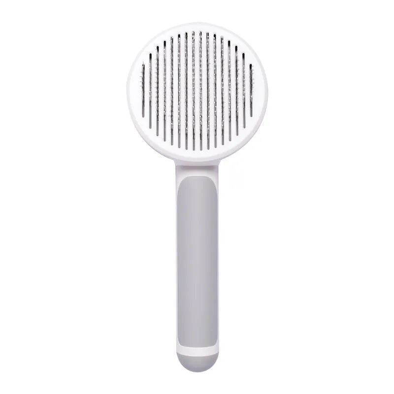 Hand-held pumpkin-coloured pet brush with stainless steel needles for grooming cats and dogs