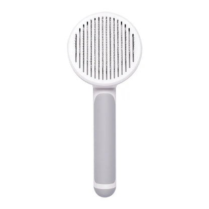 Hand-held pumpkin-coloured pet brush with stainless steel needles for grooming cats and dogs