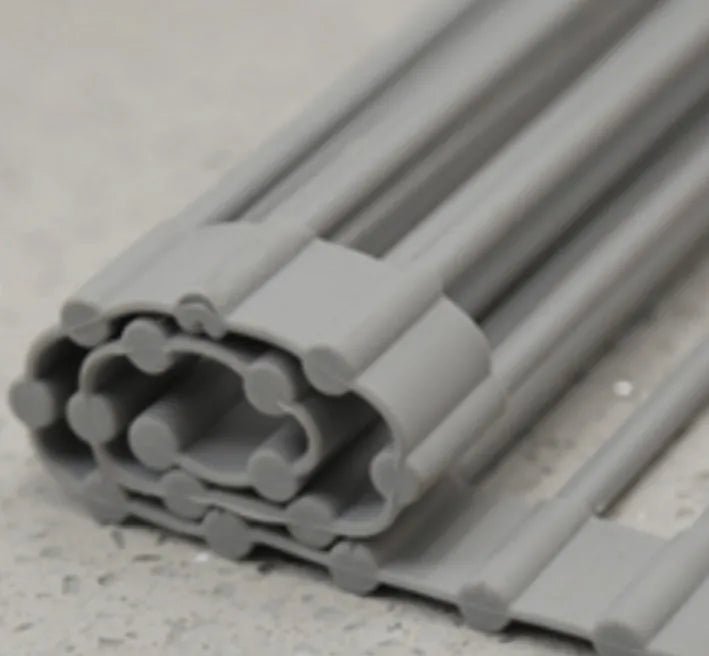 Folding stainless steel kitchen drain rack with coloured plastic tubes, shown open for use.