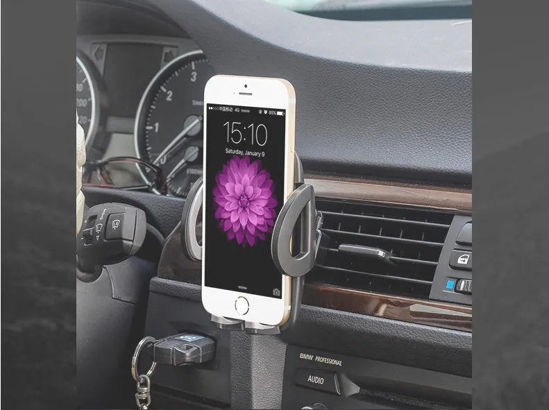 Black universal car air vent mobile phone holder attached to a vehicle vent, showing adjustable arms and 360-degree rotation.