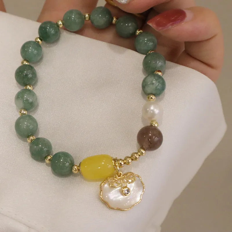 Light green jade bead bracelet with a shell charm and adjustable metal clasp.