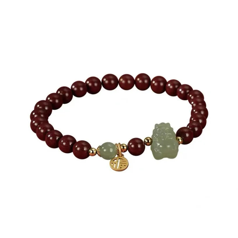 Natural Hetian jade bracelet with zodiac carvings and cinnabar accents in 8mm diameter