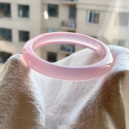 Natural agate wide tire bracelet in pink, showing polished stone beads on a wrist.