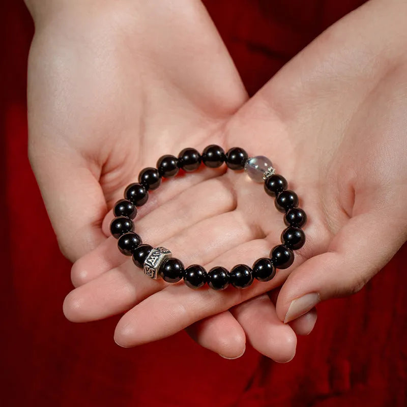 Obsidian bead bracelet with zodiac animal and Buddhist bodhisattva inlay designs.