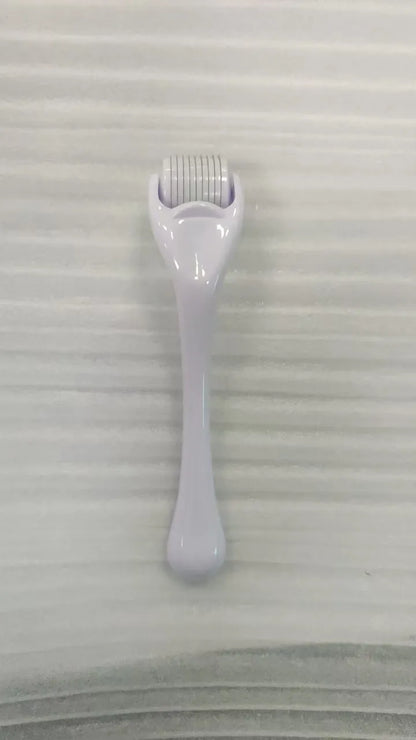 Sterile micro needle derma roller with black handle and coloured wheel on white background