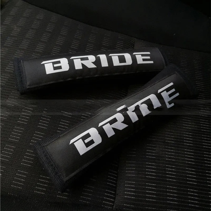 Car seat belt shoulder pad protectors in black, blue, and red colours with embroidered woven detailing