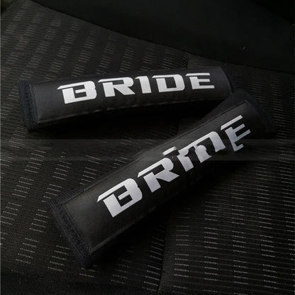 Car seat belt shoulder pad protectors in black, blue, and red colours with embroidered woven detailing