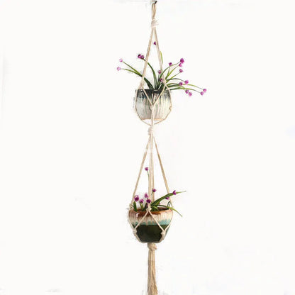 Handwoven natural cotton rope plant hanger cradling a green potted succulent on a wooden table.