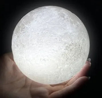 3D printed white moon lamp on a wooden holder, showing detailed crater texture and soft LED glow.