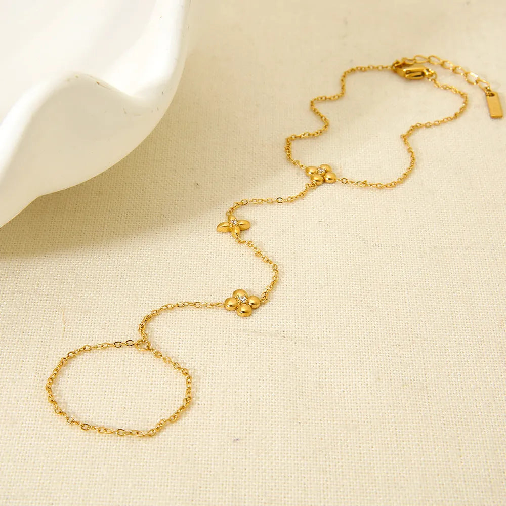 Gold stainless steel women's bracelet with geometric design of eight pointed stars and flowers.