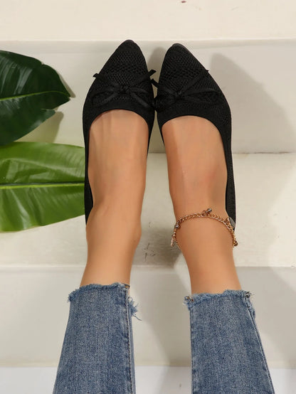 Women's blue knitted loafer flat shoes with a pointed toe and decorative bow detail on the front.