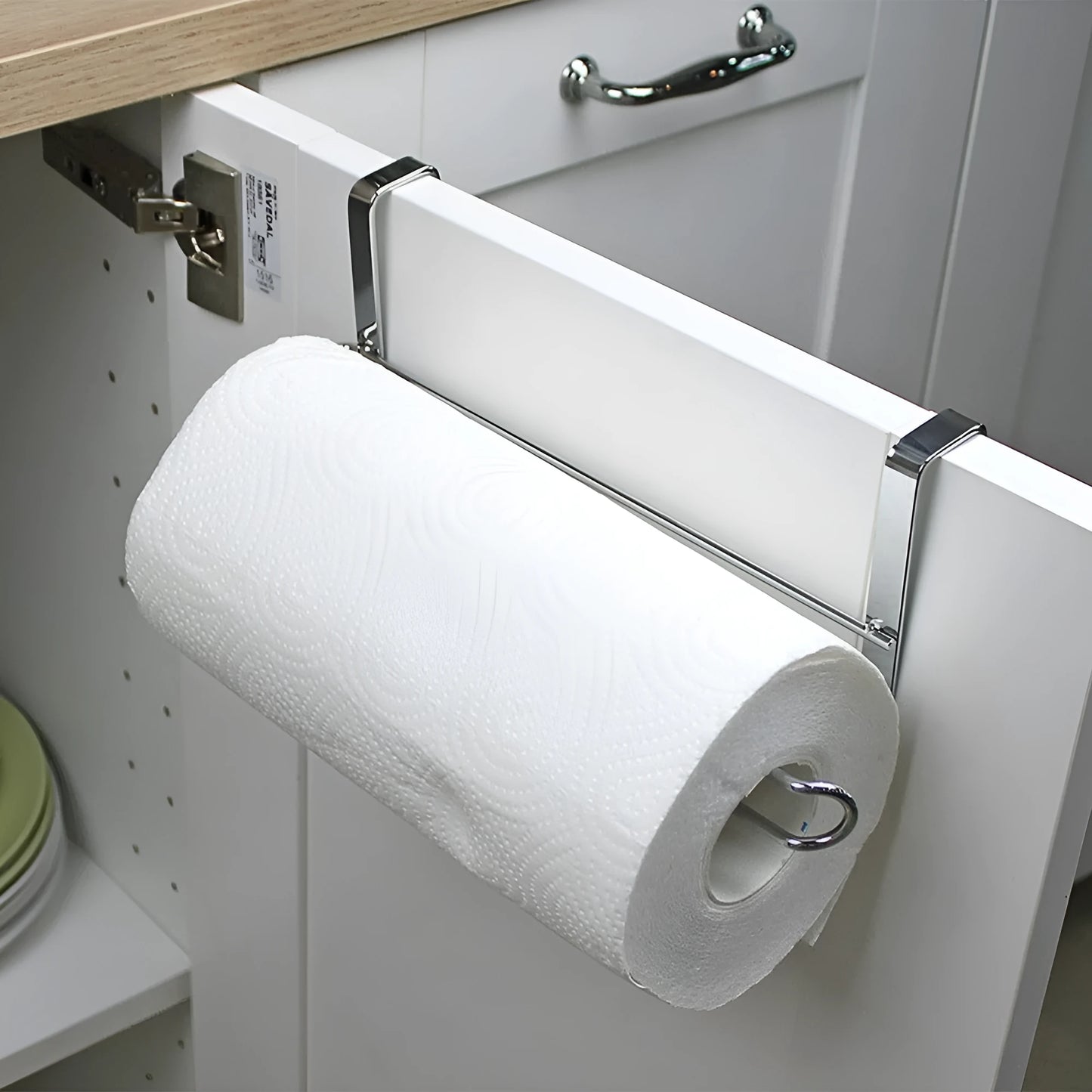 Silver stainless steel paper towel rack hanging on a cabinet door