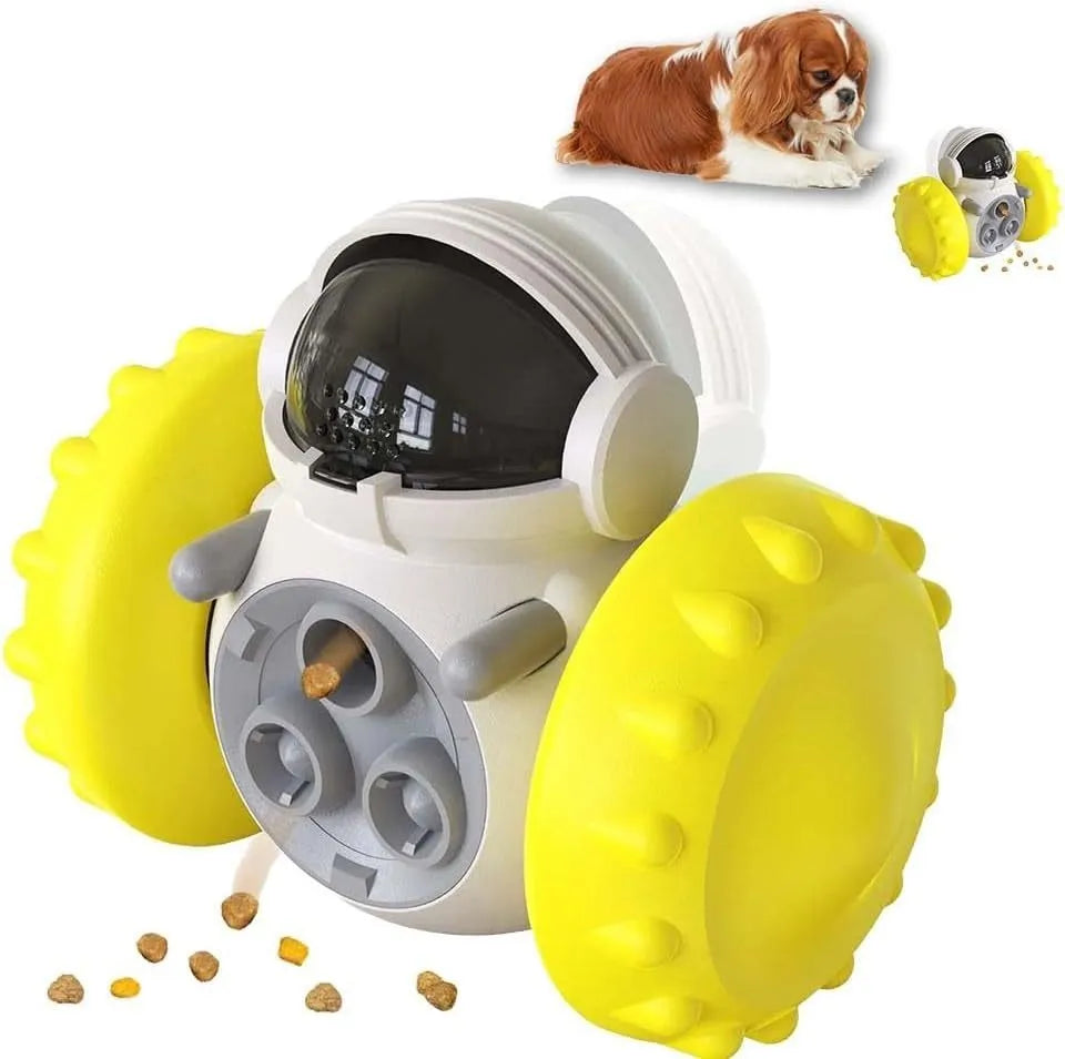 A black, robot-shaped treat dispenser toy for dogs and cats on a wooden floor, showing its size and rolling design.
