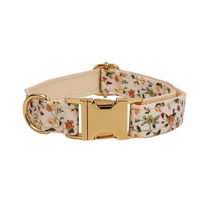 Small white flower decoration on a cloth dog collar and leash set with matching vest and bow.