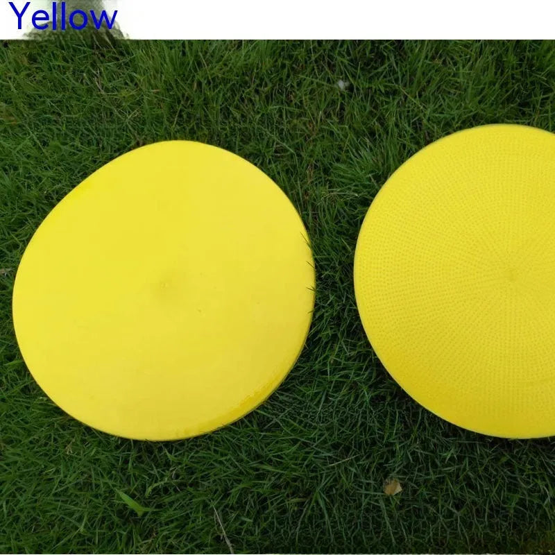 Soft yellow TPE football training landmark pad disc on grass, 23cm diameter.