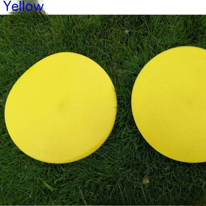 Soft yellow TPE football training landmark pad disc on grass, 23cm diameter.