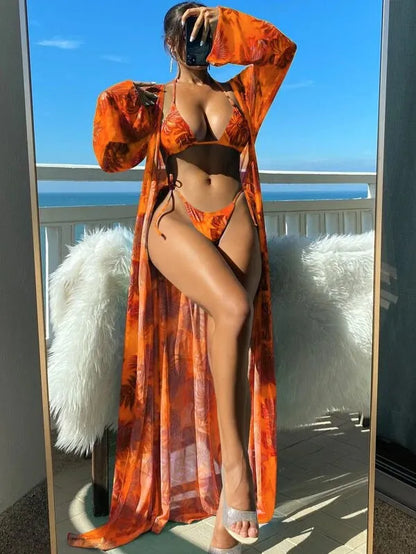Polyester banded bikini set with long sleeve blouse, briefs, and robe cover-up in floral pattern