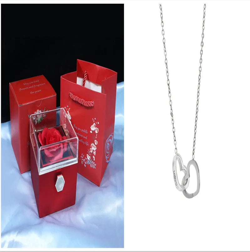 Rotating rose jewellery gift box with a preserved red rose under a clear acrylic dome, showing the interior rotating drawer.