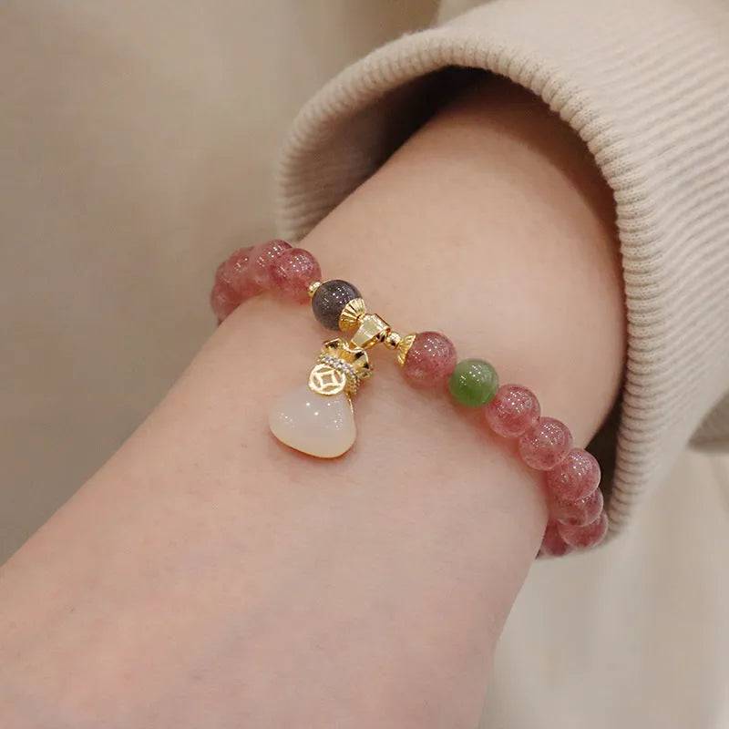 Natural strawberry quartz geometric bracelet with a small purse charm and silver safety buckle closure.