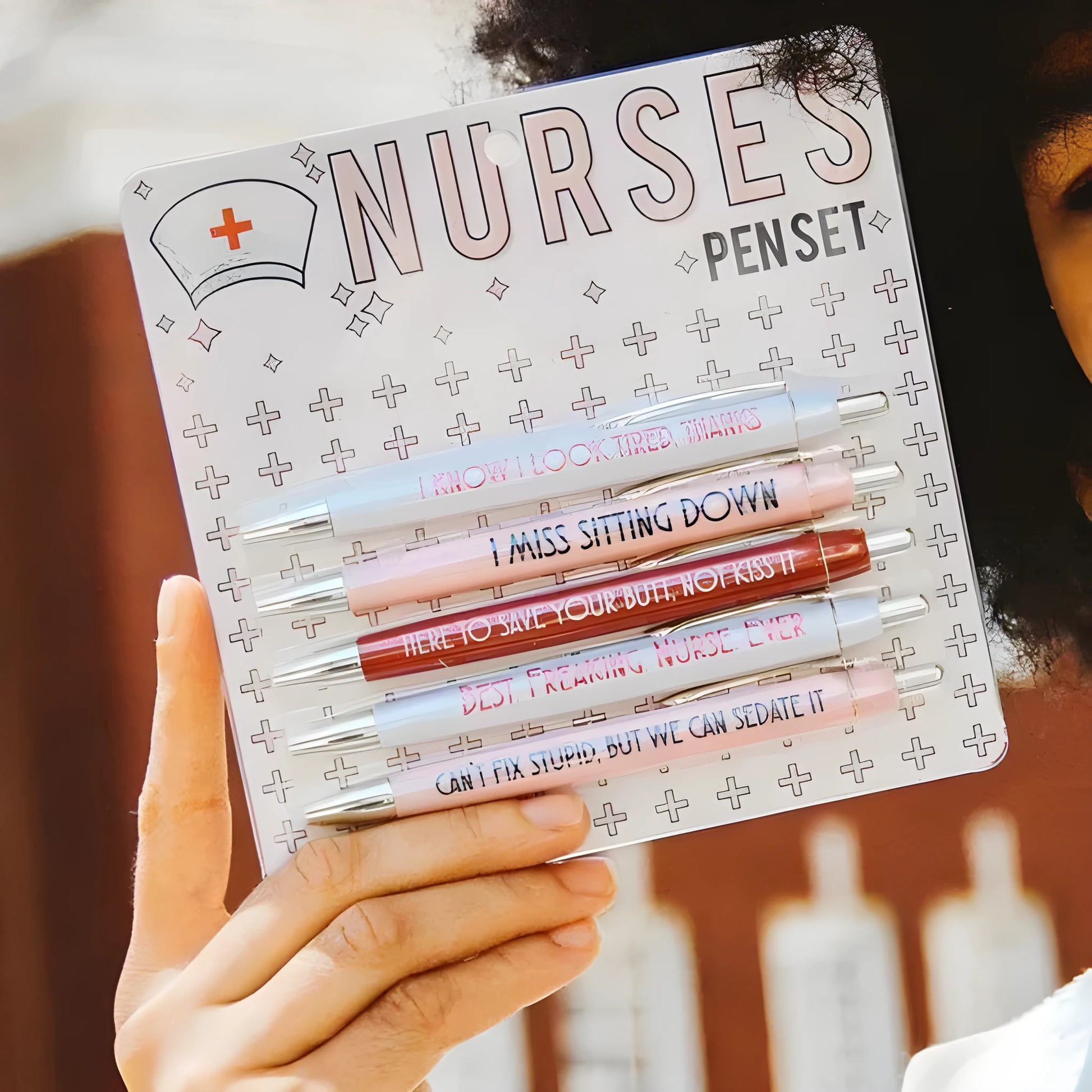 Set of five white plastic retractable ballpoint pens with blue and red nurse-themed text and graphics.