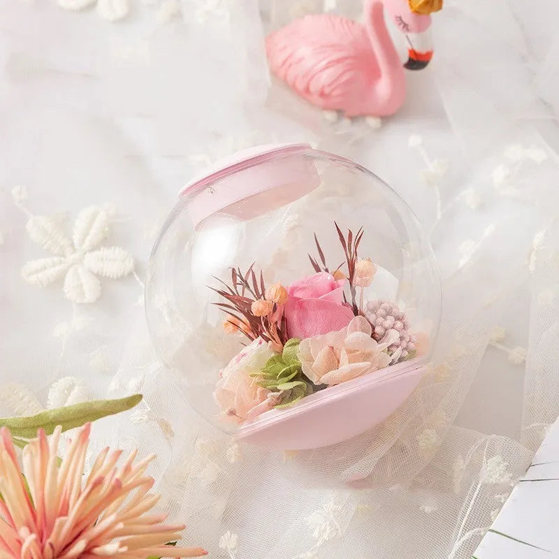 Pink preserved rose ornament with Bluetooth speaker and LED light on wooden table