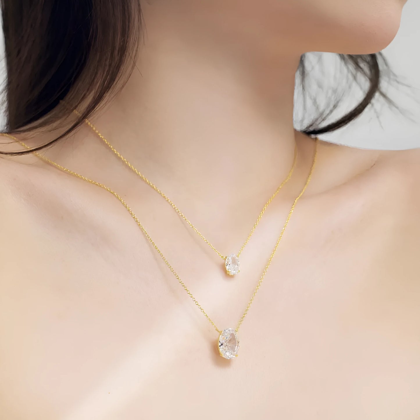Close-up of a geometric oval ice flower pendant on a sterling silver necklace, showing gold or platinum finish.