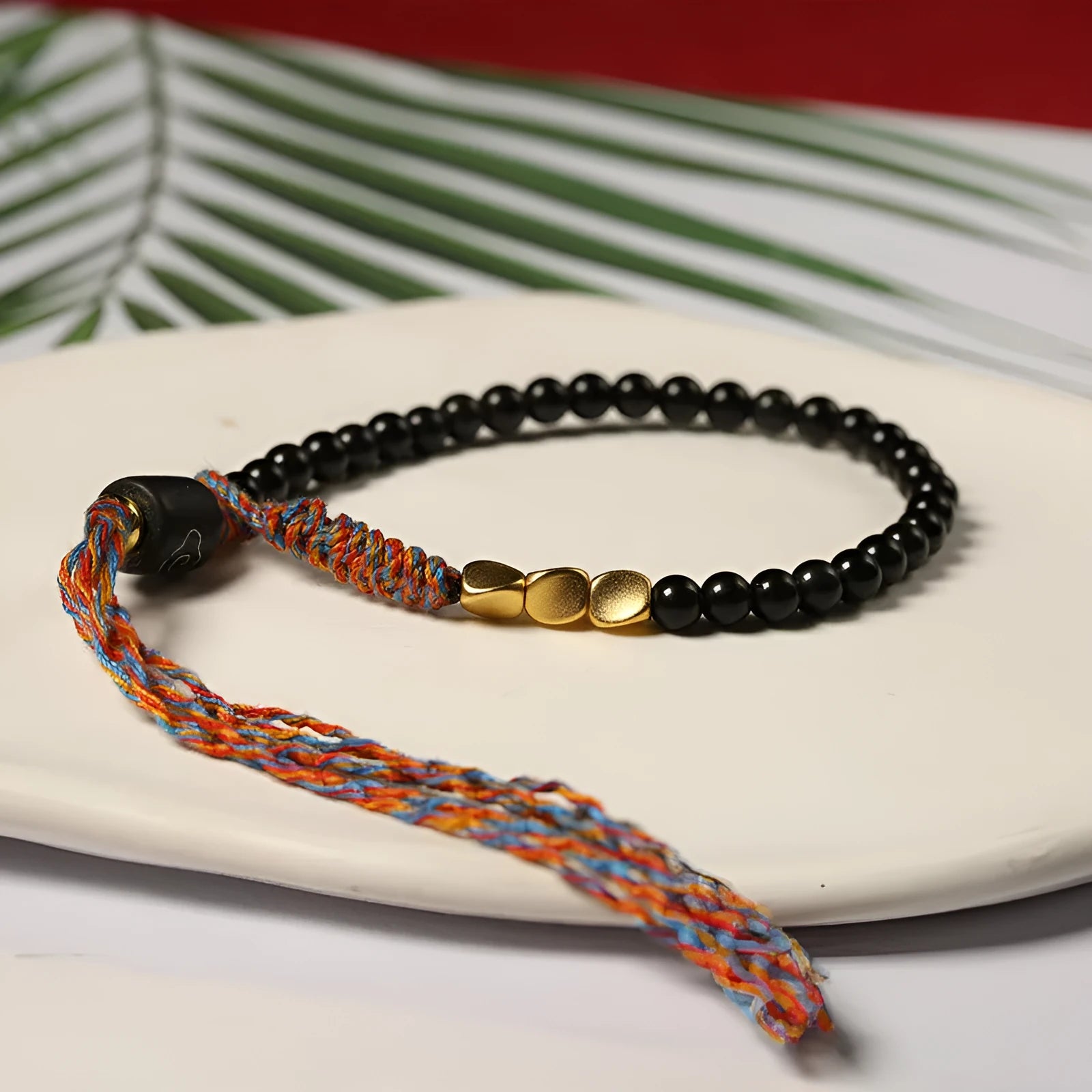 Close-up of a hand-woven obsidian bracelet with a 4mm wide strap on a wrist.