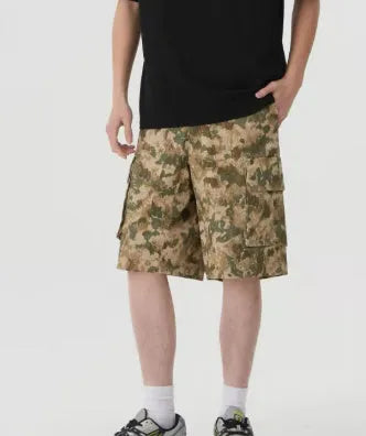 Man wearing loose-fit cropped camouflage shorts in a retro workwear style.