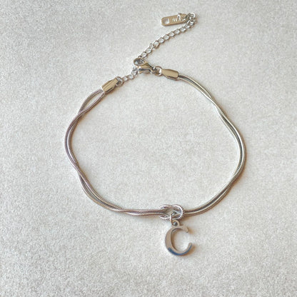 Elegant letter charm bracelets for women in gold and silver tones, featuring a delicate snake chain design and personalised letter charms.