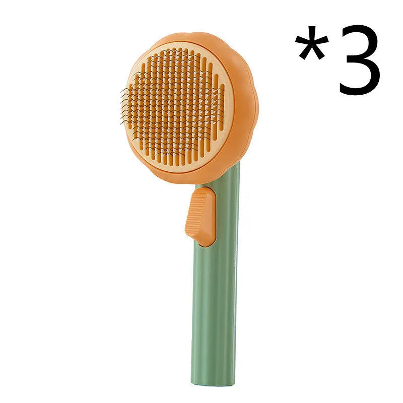 Hand-held pumpkin-coloured pet brush with stainless steel needles for grooming cats and dogs