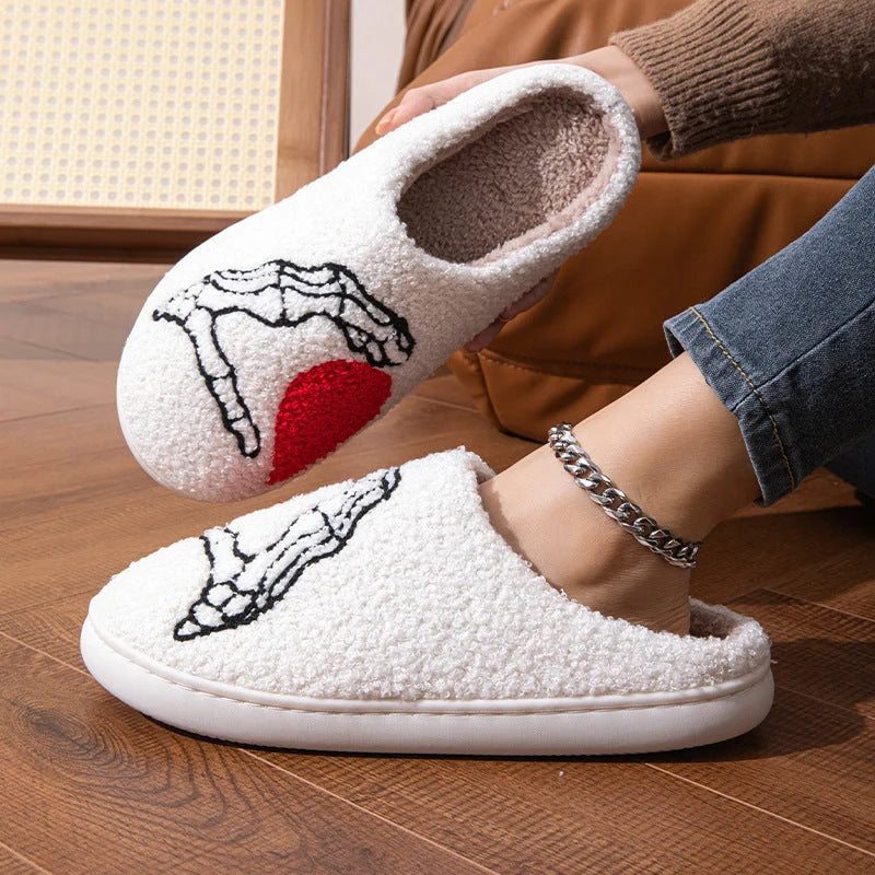 Halloween-themed skull-hand slippers in black and white, featuring non-slip soles for indoor comfort.