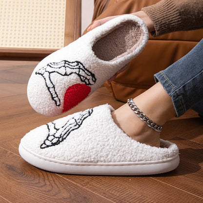 Halloween-themed skull-hand slippers in black and white, featuring non-slip soles for indoor comfort.