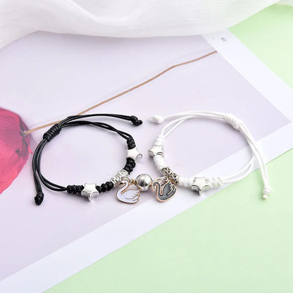 A pair of magnet couple bracelets with a suction clasp, showing various design options like clovers, crowns, and hearts.