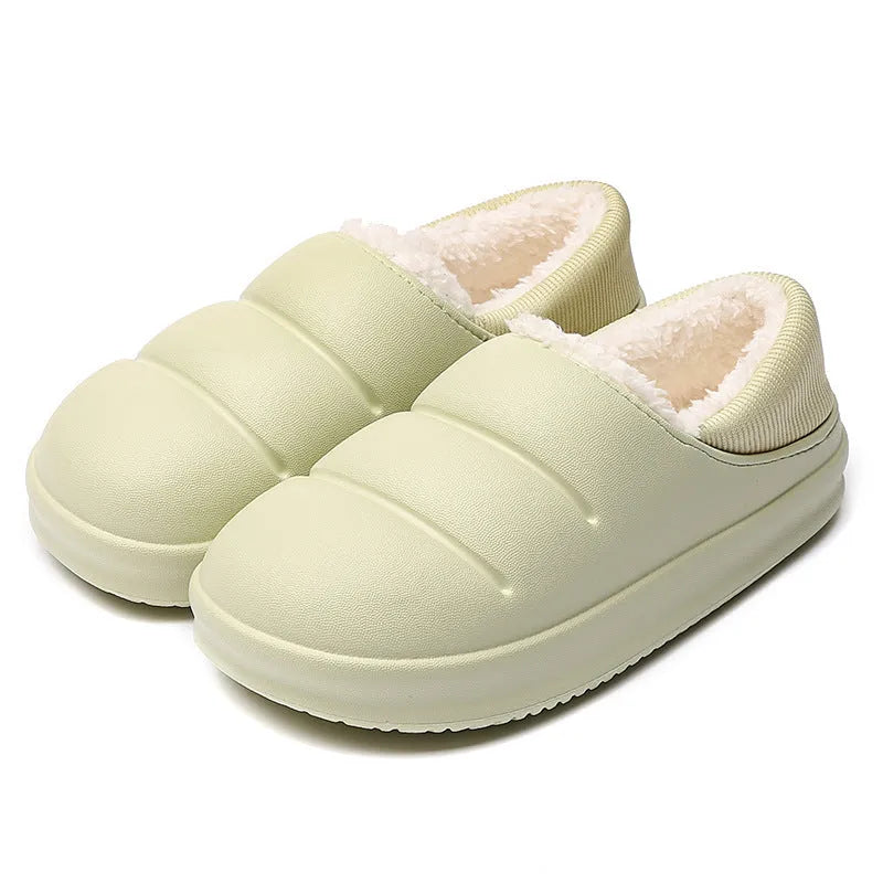 Pair of yellow waterproof EVA slippers with plush lining and a textured non-slip sole on a wooden floor.