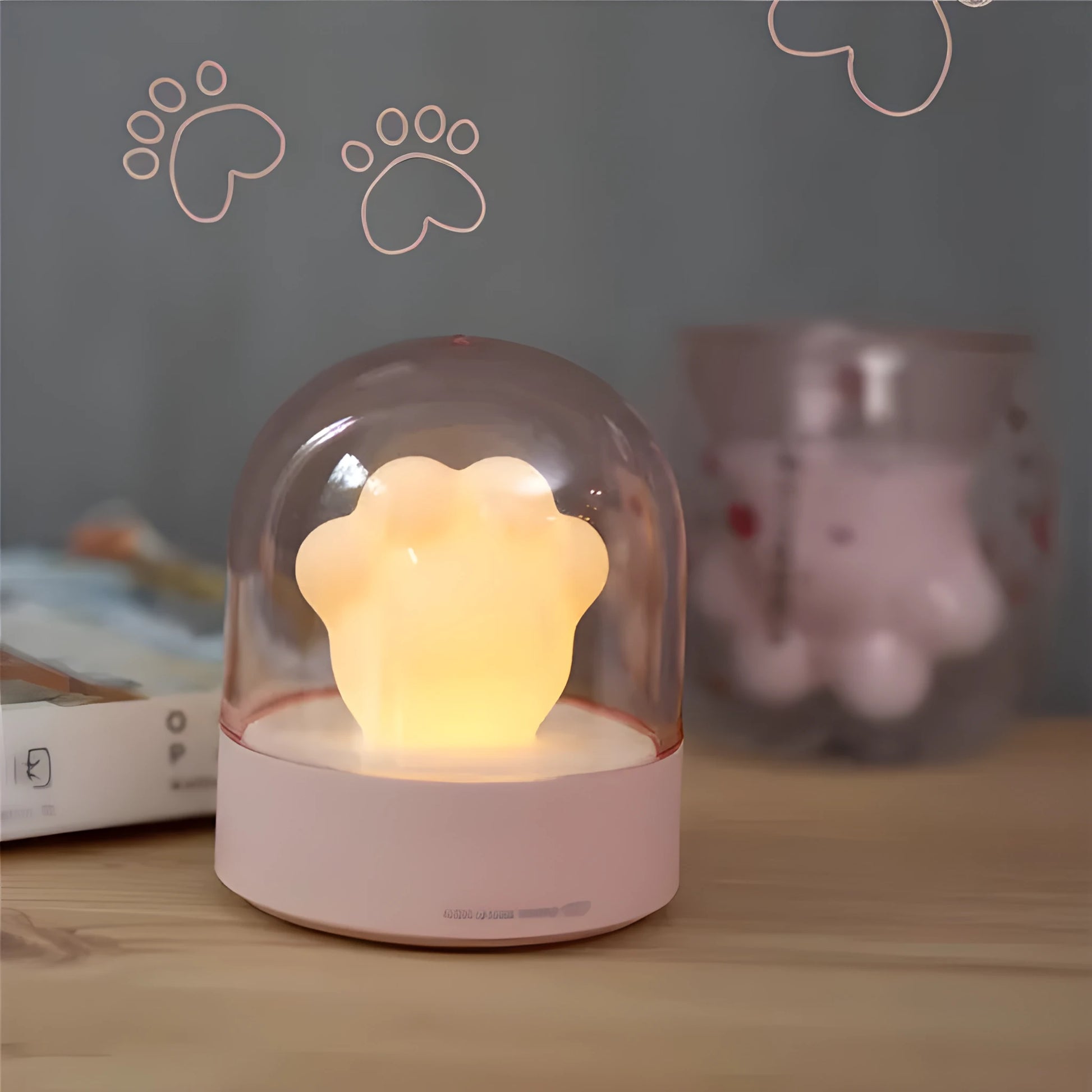Grey cat paw night light with USB cable on a wooden desk, showing soft glow and detailed paw sculpt.