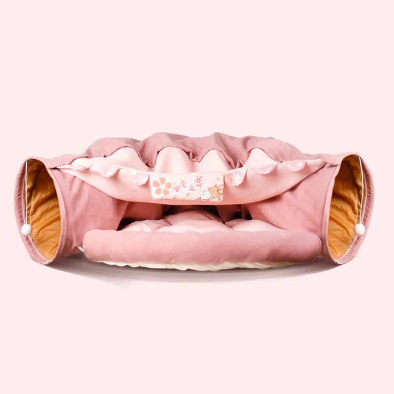 Collapsible cloth cat tunnel in pink colour, shown in both open and folded positions.
