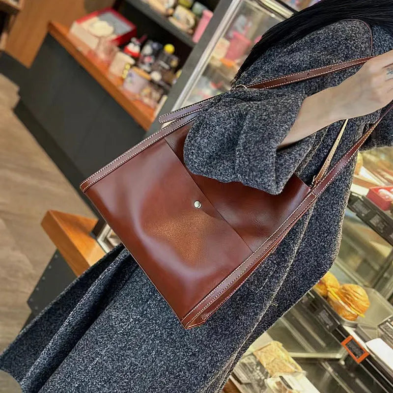 Genuine leather women's tote bag in a square shape with multiple internal pockets, shown in sunset yellow.