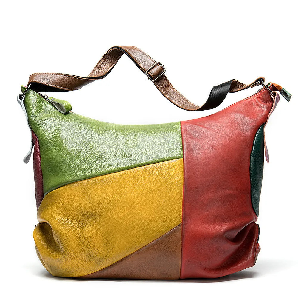Brown cowhide leather travel bag with crossbody strap, showing stitching detail.