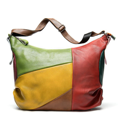 Brown cowhide leather travel bag with crossbody strap, showing stitching detail.