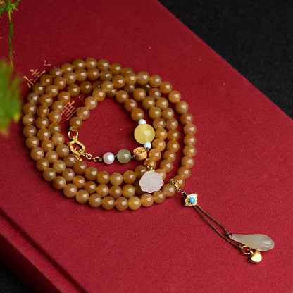 Women's green pine bead bracelet with jade leaves and sequin details on wrist