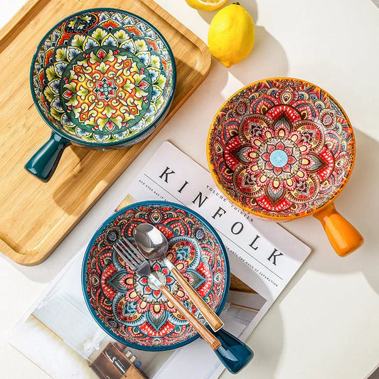 Elegant ceramic bowls with floral handles in blue, red, and green glazed finishes, perfect for serving salads and desserts