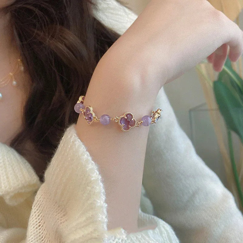 Women's artificial amethyst bracelet with U-shape design showing square stones, round stones, pearl and four-leaf clover charms