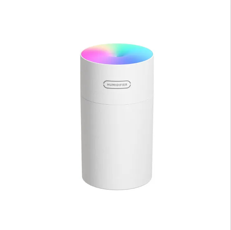 Pink USB desktop humidifier with LED lights and water tank on wooden desk