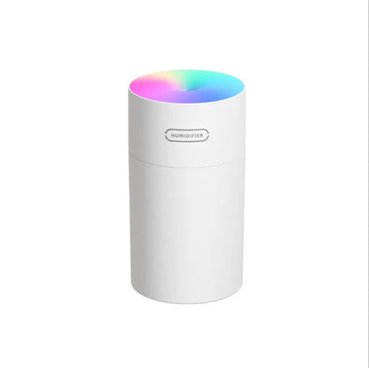 Pink USB desktop humidifier with LED lights and water tank on wooden desk