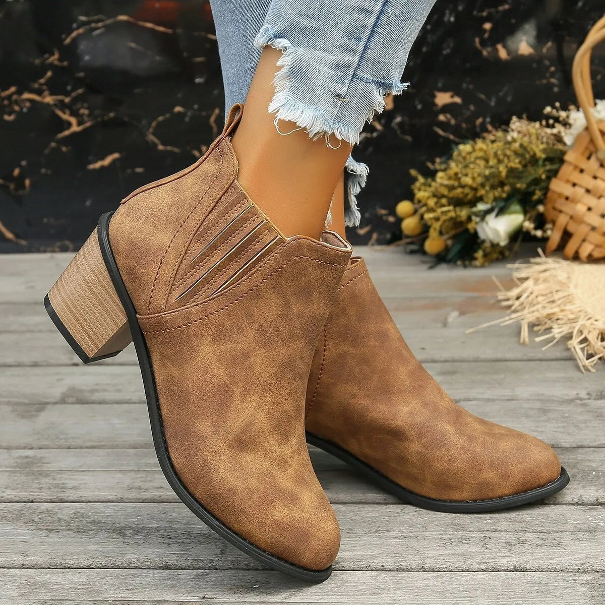 Black women's pointed toe ankle boots with a thick low square heel and slip-on design.