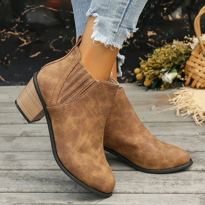 Black women's pointed toe ankle boots with a thick low square heel and slip-on design.